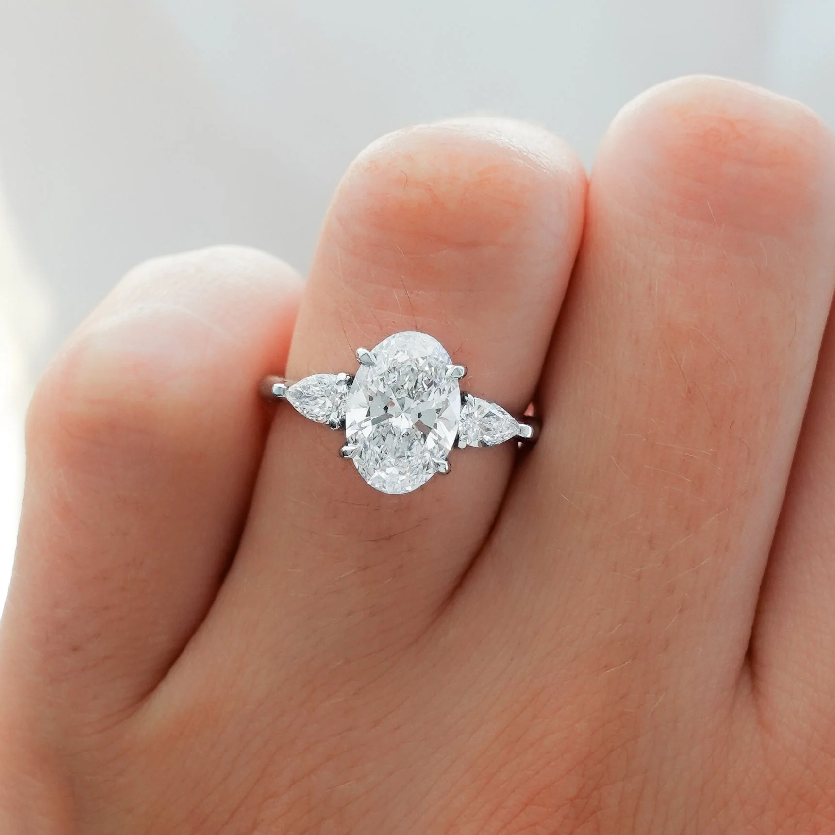 Three Stone Engagement Ring With Pear Side Stones and Oval Cut Diamond - Image 3